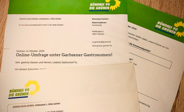 Foto zeigt auf Papier ausgedruckten Fragebogen mit Briefumschlag