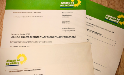 Foto zeigt auf Papier ausgedruckten Fragebogen mit Briefumschlag